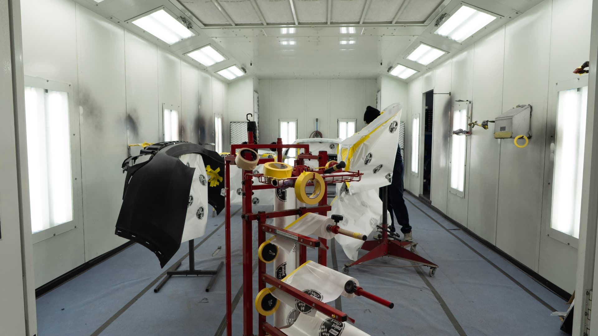Inside the downdraft paint booth with masked panels ready for refinishing