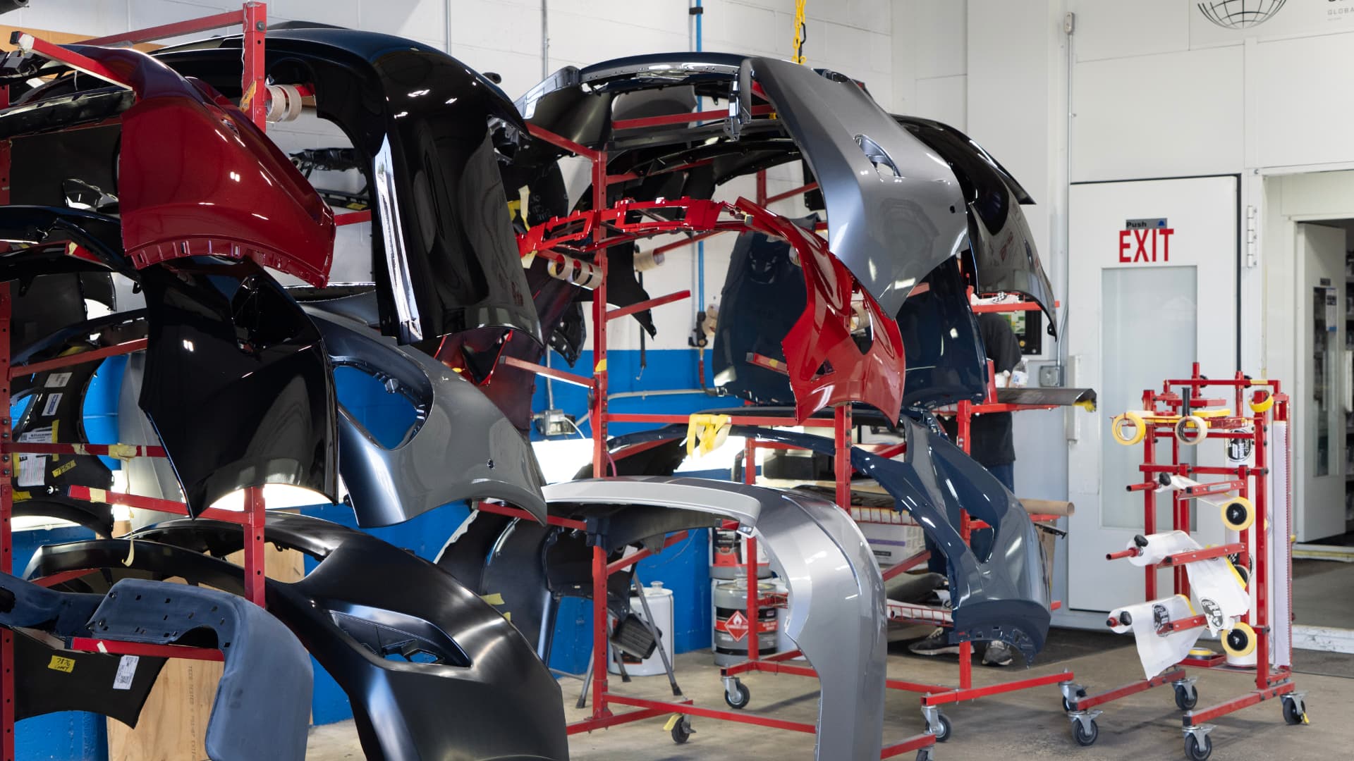 Racks of freshly painted bumpers and fenders awaiting installation