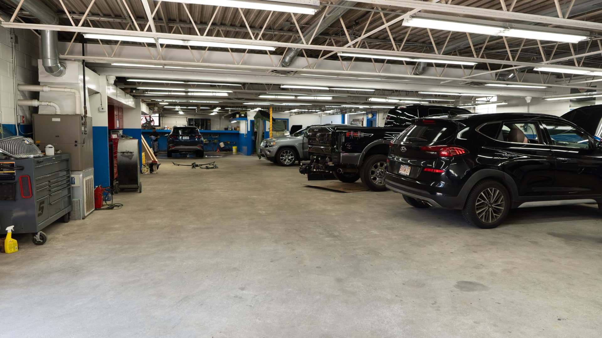 Vehicles being repaired inside the Chalkstone Auto Body shop in Providence, RI